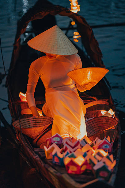 istock Traditional multicolored paper lanterns with candles floating down the river at night and beautiful woman with Vietnam culture traditional 2207289963