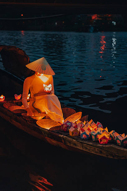 istock Traditional multicolored paper lanterns with candles floating down the river at night and beautiful woman with Vietnam culture traditional 2207289967