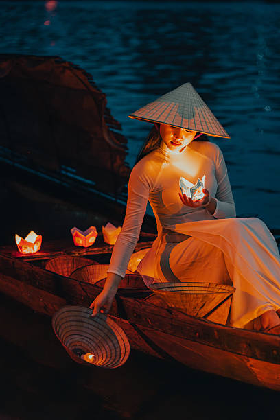 istock Traditional multicolored paper lanterns with candles floating down the river at night and beautiful woman with Vietnam culture traditional 2207289976