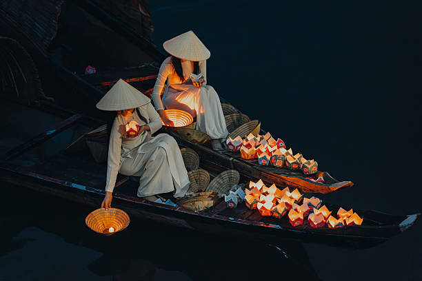 istock Traditional multicolored paper lanterns with candles floating down the river at night and beautiful woman with Vietnam culture traditional 2207289986