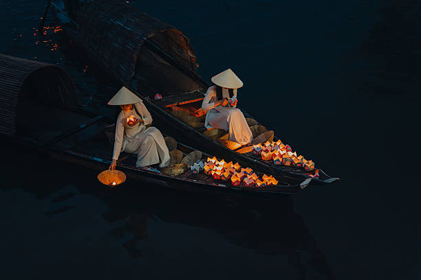 istock Traditional multicolored paper lanterns with candles floating down the river at night and beautiful woman with Vietnam culture traditional 2207289987