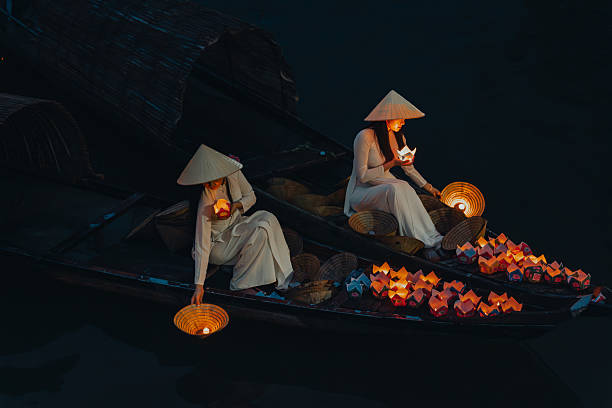 istock Traditional multicolored paper lanterns with candles floating down the river at night and beautiful woman with Vietnam culture traditional 2207289989