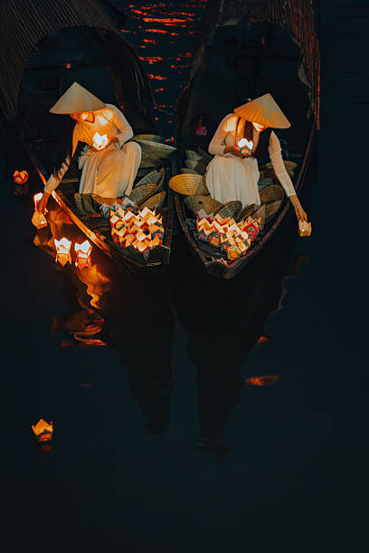 istock Traditional multicolored paper lanterns with candles floating down the river at night and beautiful woman with Vietnam culture traditional 2207289994