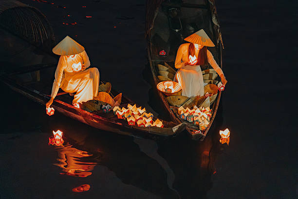 istock Traditional multicolored paper lanterns with candles floating down the river at night and beautiful woman with Vietnam culture traditional 2207289999