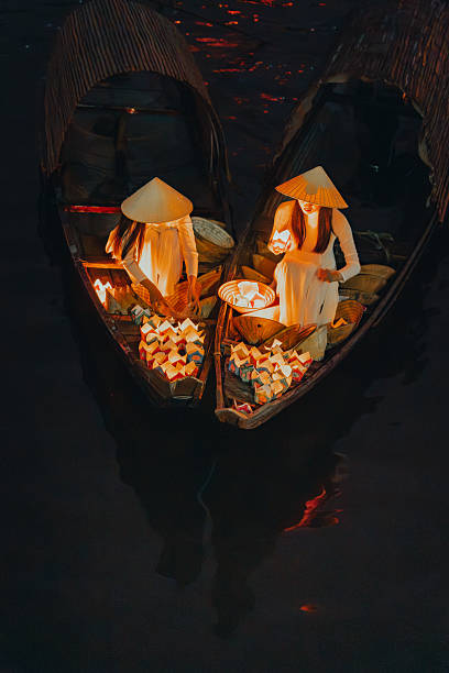 istock Traditional multicolored paper lanterns with candles floating down the river at night and beautiful woman with Vietnam culture traditional 2207290000