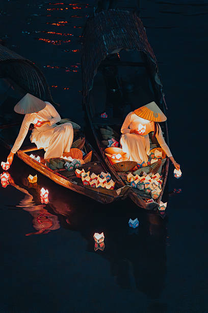 istock Traditional multicolored paper lanterns with candles floating down the river at night and beautiful woman with Vietnam culture traditional 2207290019