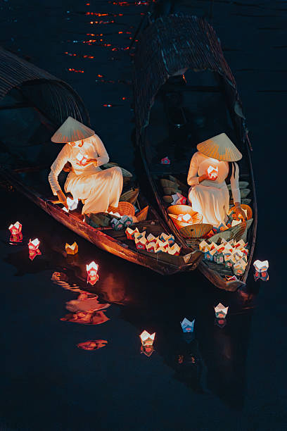 istock Traditional multicolored paper lanterns with candles floating down the river at night and beautiful woman with Vietnam culture traditional 2207290022