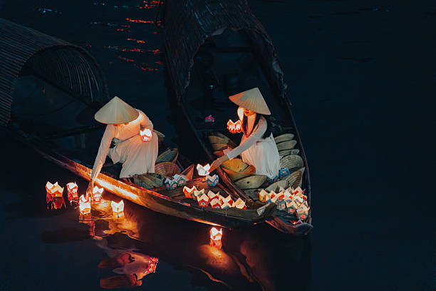 istock Traditional multicolored paper lanterns with candles floating down the river at night and beautiful woman with Vietnam culture traditional 2207290040