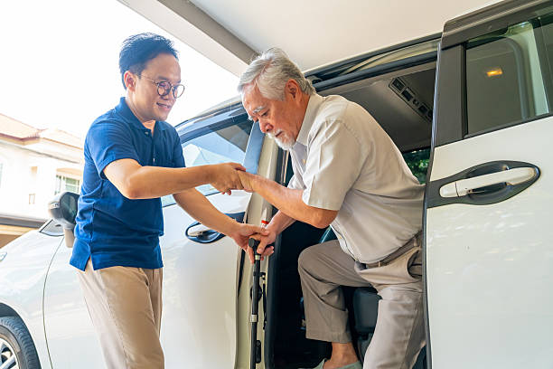 istock Caregiver helping senior man get in the car. 2207290459