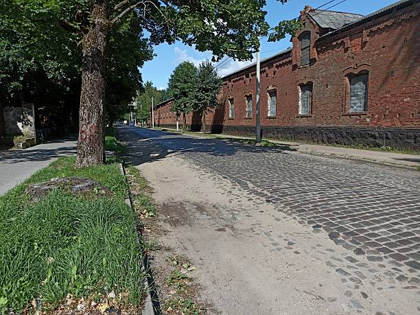 istock A cobbled street lined with a long brick building with boarded-up windows 2207291880