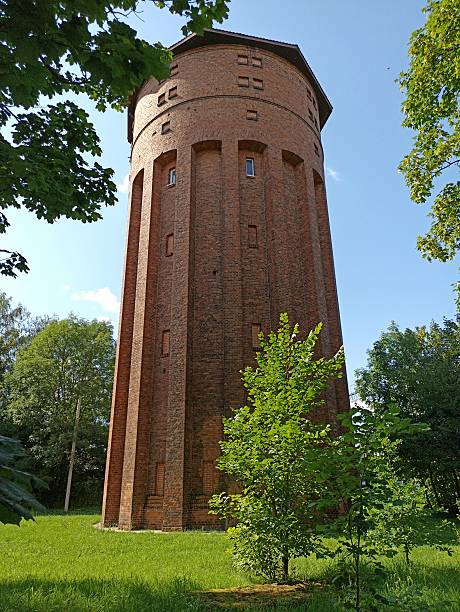 istock Tall brick water tower surrounded by green trees and grass 2207292093