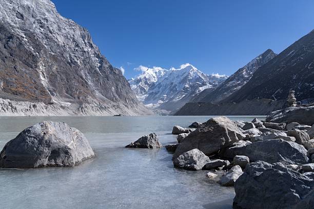 istock Frozen lake and snow-capped mountains under blue sky. 2207295030