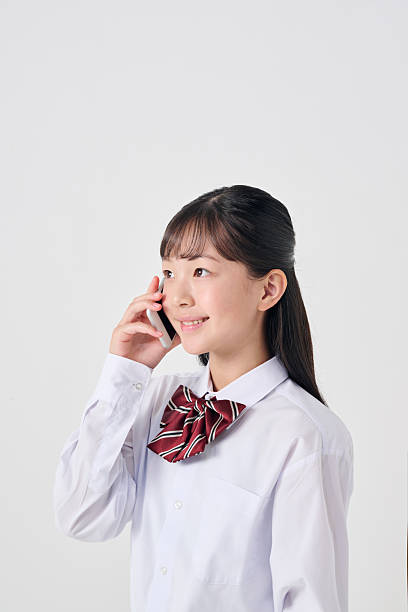 istock Japanese junior high school girl making a phone call 2207299505
