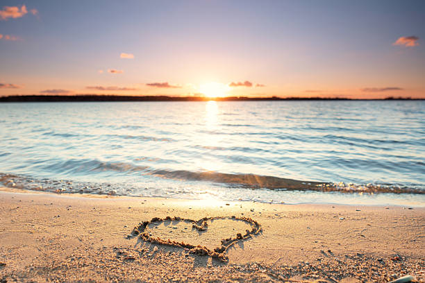 istock heart in the sand on the beach with summer sunset 2207299943