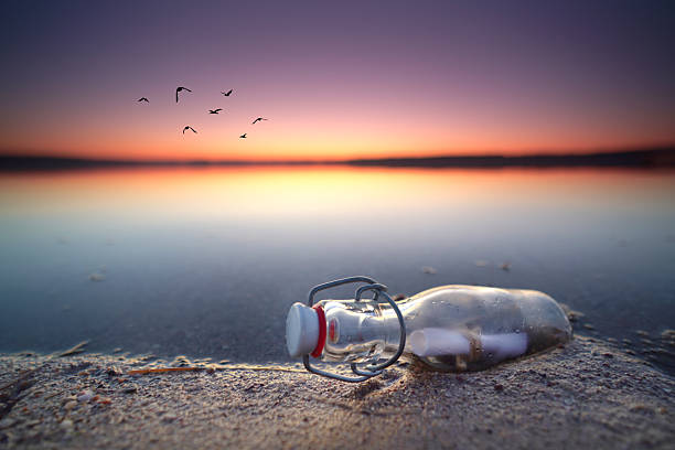 glass bottle with letter in sunset light on the beach