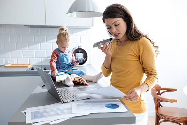 Mother multitasking while toddler sits on the counter drawing with pencils