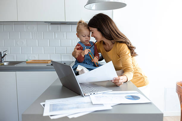 istock Mother balancing work and family while engaging with her child in the kitchen 2207301027
