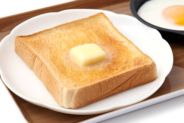 sliced toasted bread and melted butter with fried egg on a plate