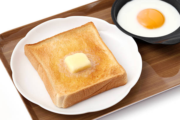 sliced toasted bread and melted butter with fried egg on a plate