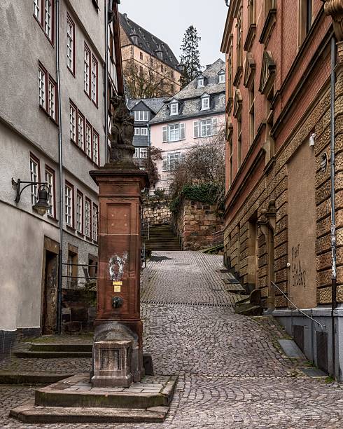 Marburg, Germany – March 01, 2025: Charming cobblestone street in historic European town with classic architecture and narrow alleyways.