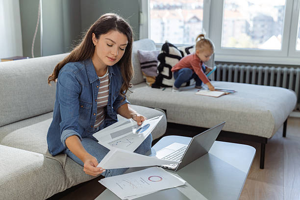 istock Mother multitasking work from home with her child playing nearby 2207301846