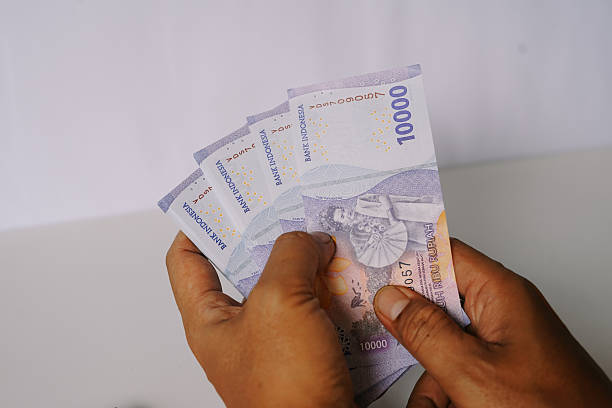 istock Hands displaying Indonesian Rupiah currency notes, financial concept 2207303973