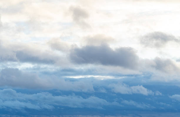 istock Stormy sky with dark, snowy clouds on a spring day. Clouds are floating across the sky. Dramatic clouds. Dark blue clouds swiftly floating across blue sky. 2207304025