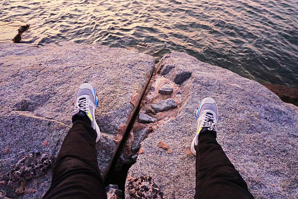 istock POV with legs at stone with sea background 2207306821