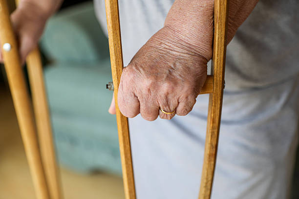 istock Close-up of an Elderly Woman's Hand Holding Crutches 2207308131