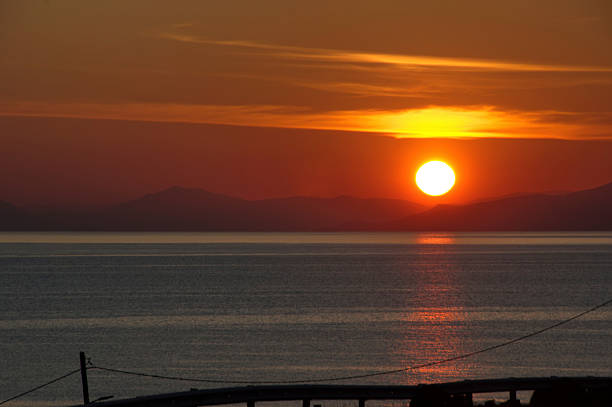 Scenic sunset with the sun dipping below the horizon, painting the sky in vibrant hues.