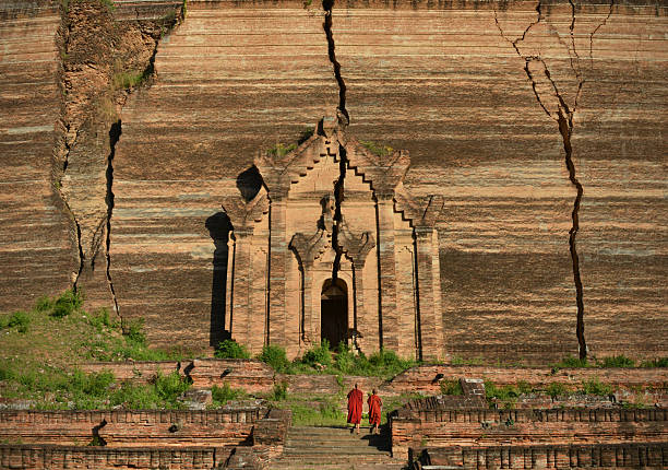 Monks at the Mingun Pahtodawgyi incomplete monument stupa in Mingun, approximately 10 kilometres (6.2 mi) northwest of Mandalay in Sagaing Region in central Myanmar (formerly Burma). The crack was caused by an earhquake  23 March 1839