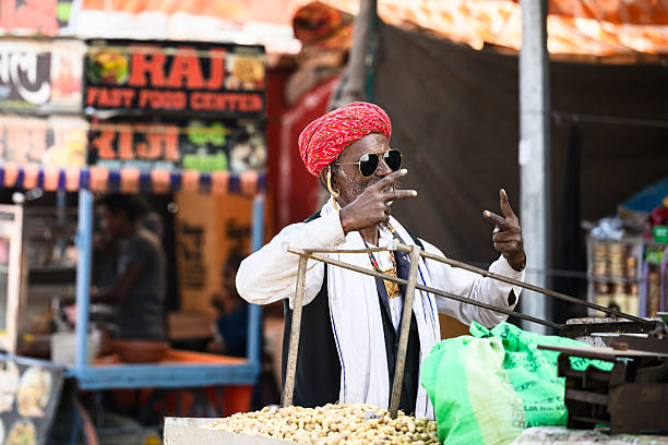 Pushkar, India - November 11, 2024: indian man with sunglasses posing for photo at camel fair in Pushkar