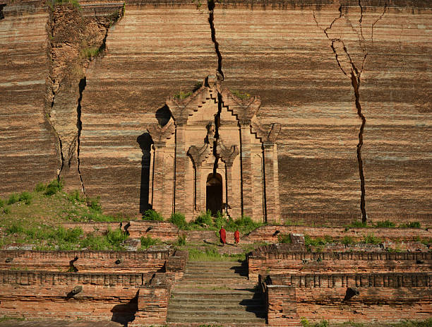 Monks at the Mingun Pahtodawgyi incomplete monument stupa in Mingun, approximately 10 kilometres (6.2 mi) northwest of Mandalay in Sagaing Region in central Myanmar (formerly Burma). The crack was caused by an earhquake  23 March 1839