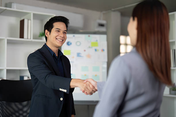 istock Networking and Professional Relations. A business associate exchanging a handshake in a modern office. 2207314878