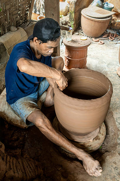 istock Indonesian potter shaping clay on a pottery wheel 2207317925