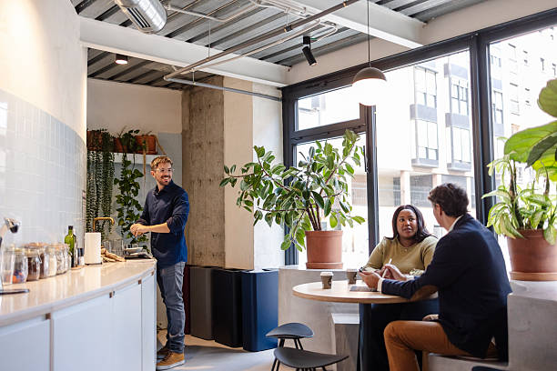 Diverse colleagues collaborating and moving around in a dynamic workspace filled with plants, showcasing a vibrant and productive atmosphere