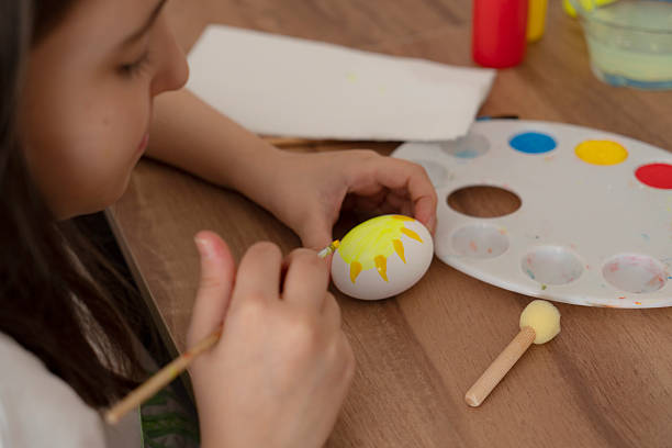 Little girl painting easter egg
