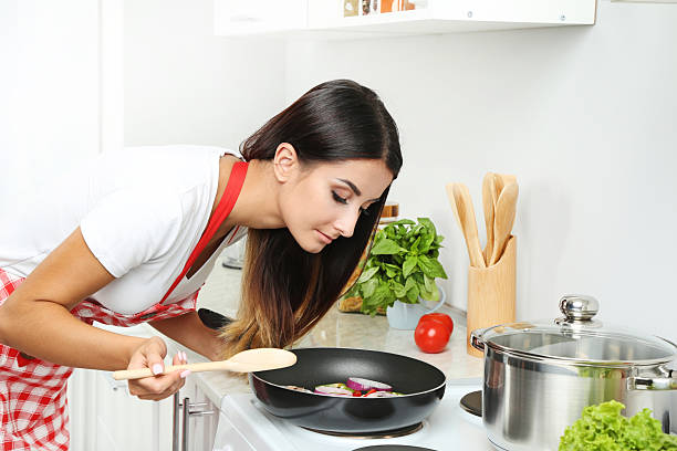 istock Beautiful young woman cooking in the kitchen 2207321628