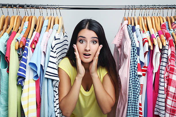 istock Young woman with different clothes on hangers 2207322127