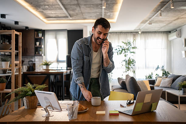 istock Freelancer enjoying a coffee while talking on the phone during his work from home day 2207323316