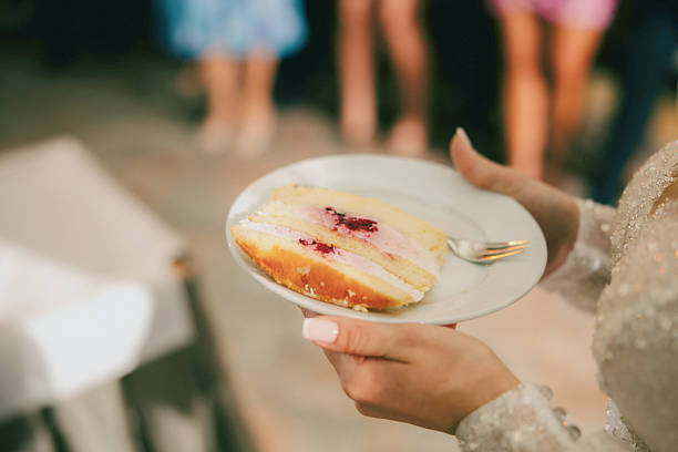 A beautiful moment of the bride and groom enjoying a piece of their wedding cake, following the traditional wedding celebration custom. A sweet and memorable part of the wedding day, symbolizing their union and joy.