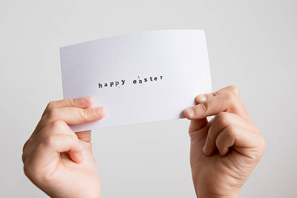 istock Hands holding Easter card with simple greeting against white background 2207326260