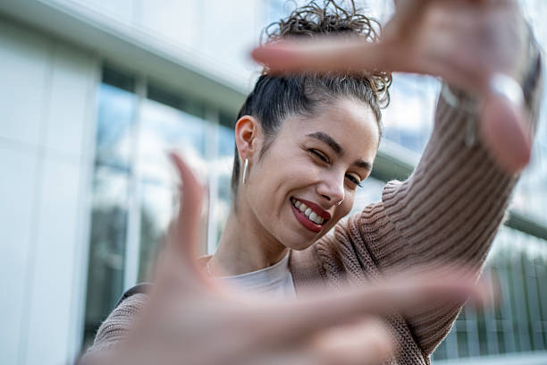 istock Young woman framing her face with hands and smiling 2207331685
