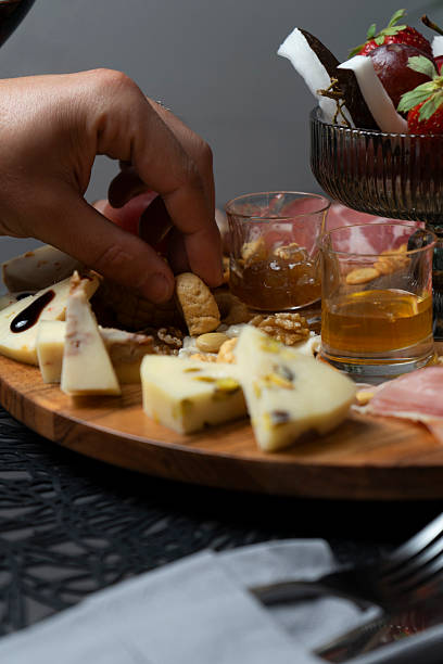 istock Hand taking a breadstick from a platter of cold cuts, cheeses and fruit 2207332119