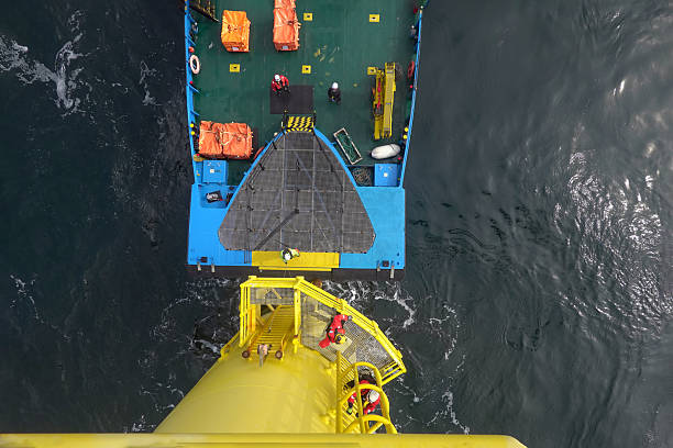 istock View from above on service vessel by wind turbine prepared for passenger transfer and technicians climbing on the wind turbine 2207332233