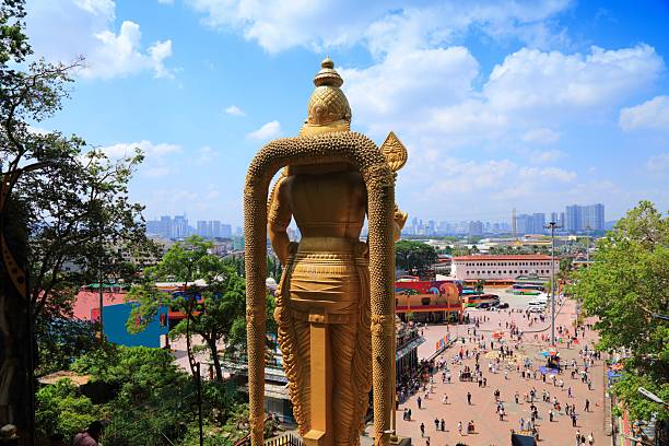 Batu Caves in Kuala Lumpur city, Malaysia. Murugan statue next to Hindu shrines.