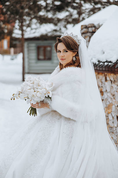istock A bride is wearing a white fur coat and a white veil 2207336959