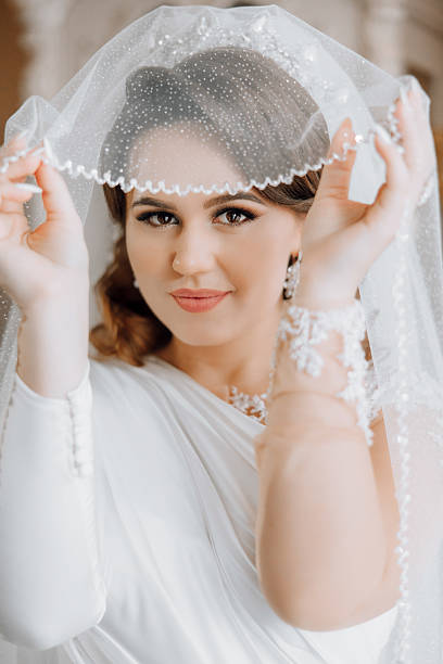 istock A woman wearing a white dress and a veil with a diamond pattern 2207337802