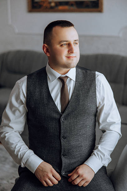 istock A man in a suit and vest sits on a couch 2207337897