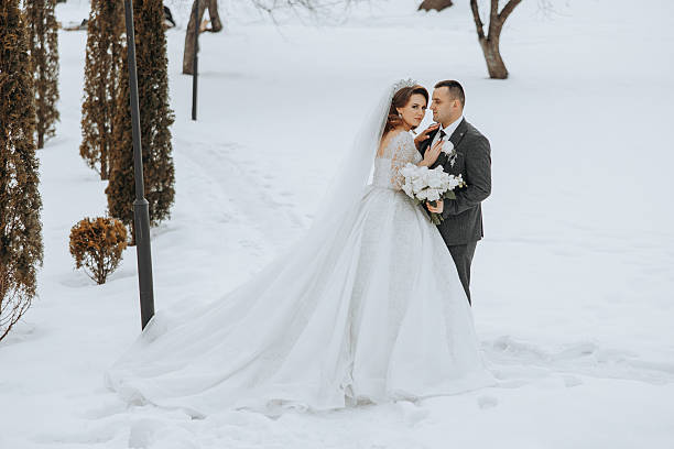 istock A bride and groom are standing in the snow 2207337941